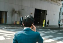 바쁜 직장인을 위한 건강 관리법, 작은 습관이 큰 변화를 만든다 A businessman talks on the phone while crossing the street.