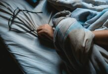 하루 종일 지친다면, 만성피로 증후군을 의심해보세요 black framed eyeglasses on blue bedsheet