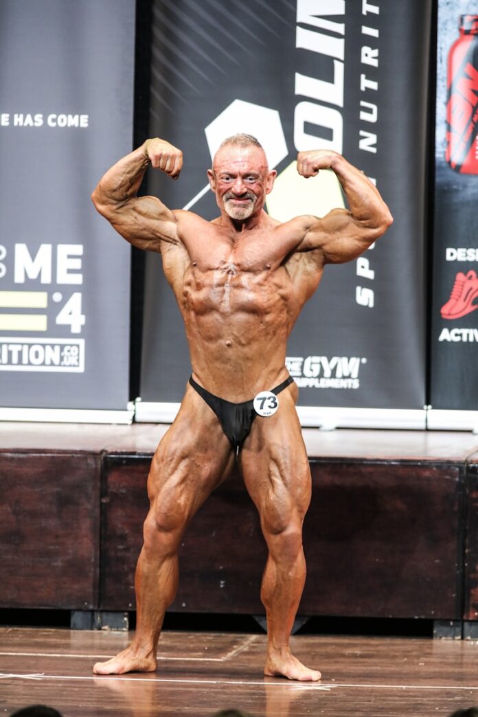 a man standing on a stage flexing his muscles
