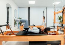 “필라테스, 건강과 일상에 스며드는 유연한 습관” a woman is doing a pivot on a pivot machine