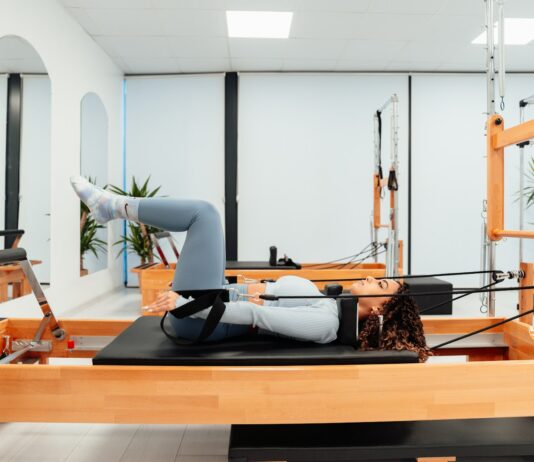 “필라테스, 건강과 일상에 스며드는 유연한 습관” a woman is doing a pivot on a pivot machine