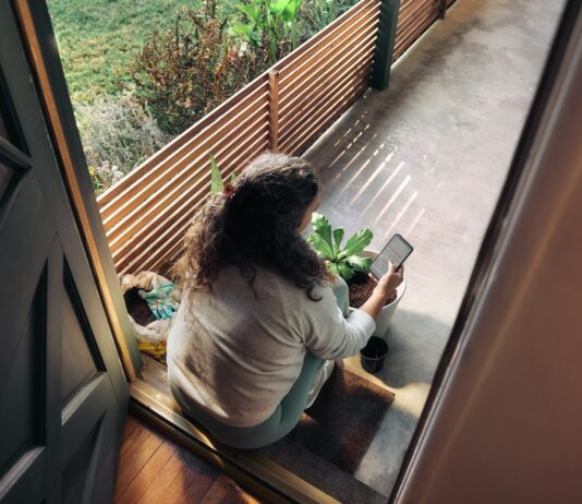 “지친 일상, 만성피로 탈출법 찾기”…작은 변화가 만드는 큰 활력 Woman sitting on balcony with smartphone
