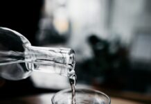 바쁜 현대인을 위한 ‘마이크로 운동’, 실생활 속 건강 챙기기 열풍 person holding bottle pouring water on drinking glass